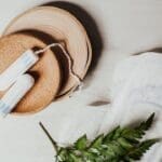 Tampons and a sanitary pad arranged on a neutral background, symbolizing menstrual health and the importance of supporting your cycle with real food.