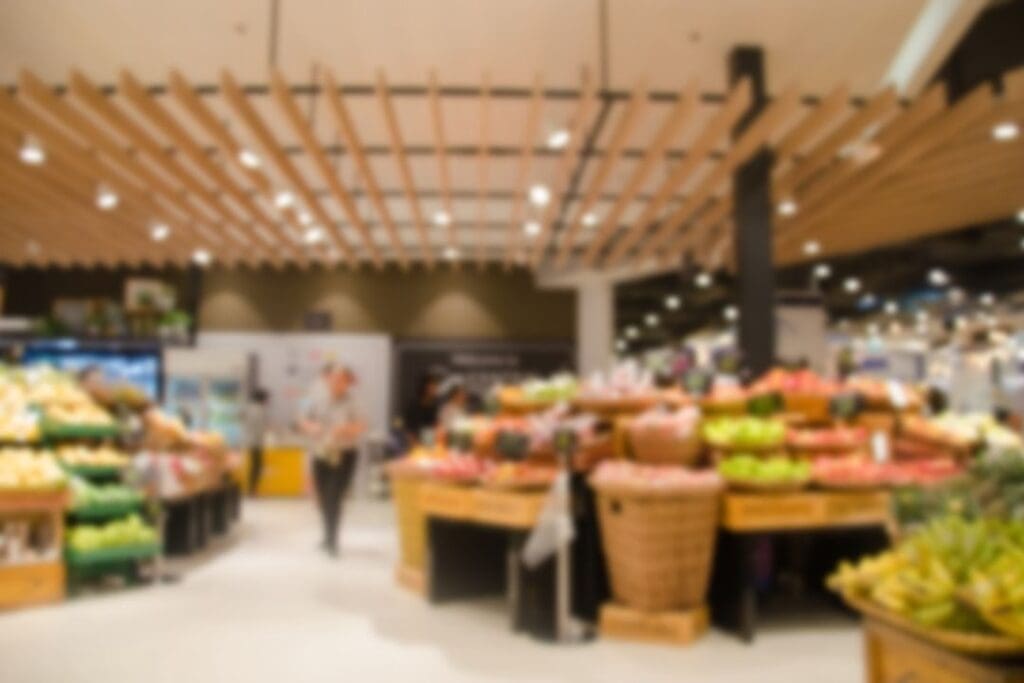 Blurred view of a grocery store produce section, representing mindful shopping and ingredient awareness.