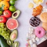 Colorful comparison of whole foods like fruits and vegetables on the left and ultra-processed foods like donuts, chips, and candy on the right.